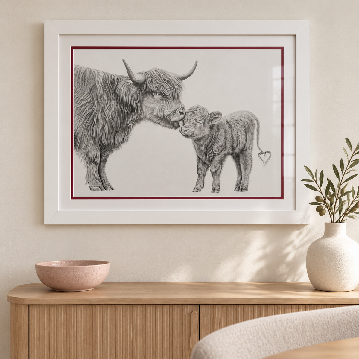 Framed Highland cow and calf drawing styled above an oak sideboard in a modern ivory interior